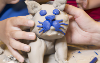 a child modeling a clay cat in an art therapy studio
